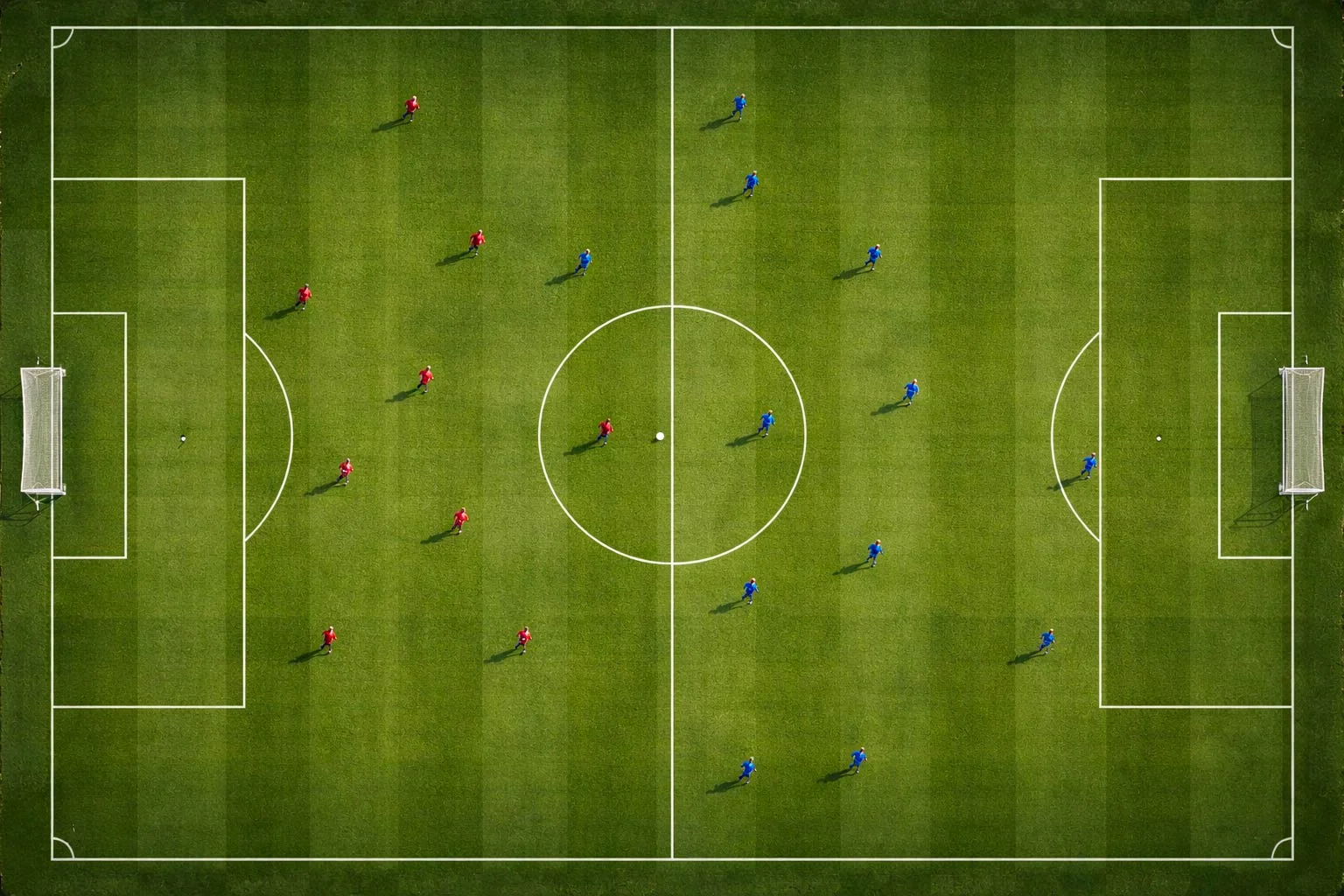 Vista cenital de un campo de fútbol con césped natural y líneas marcadas durante un partido